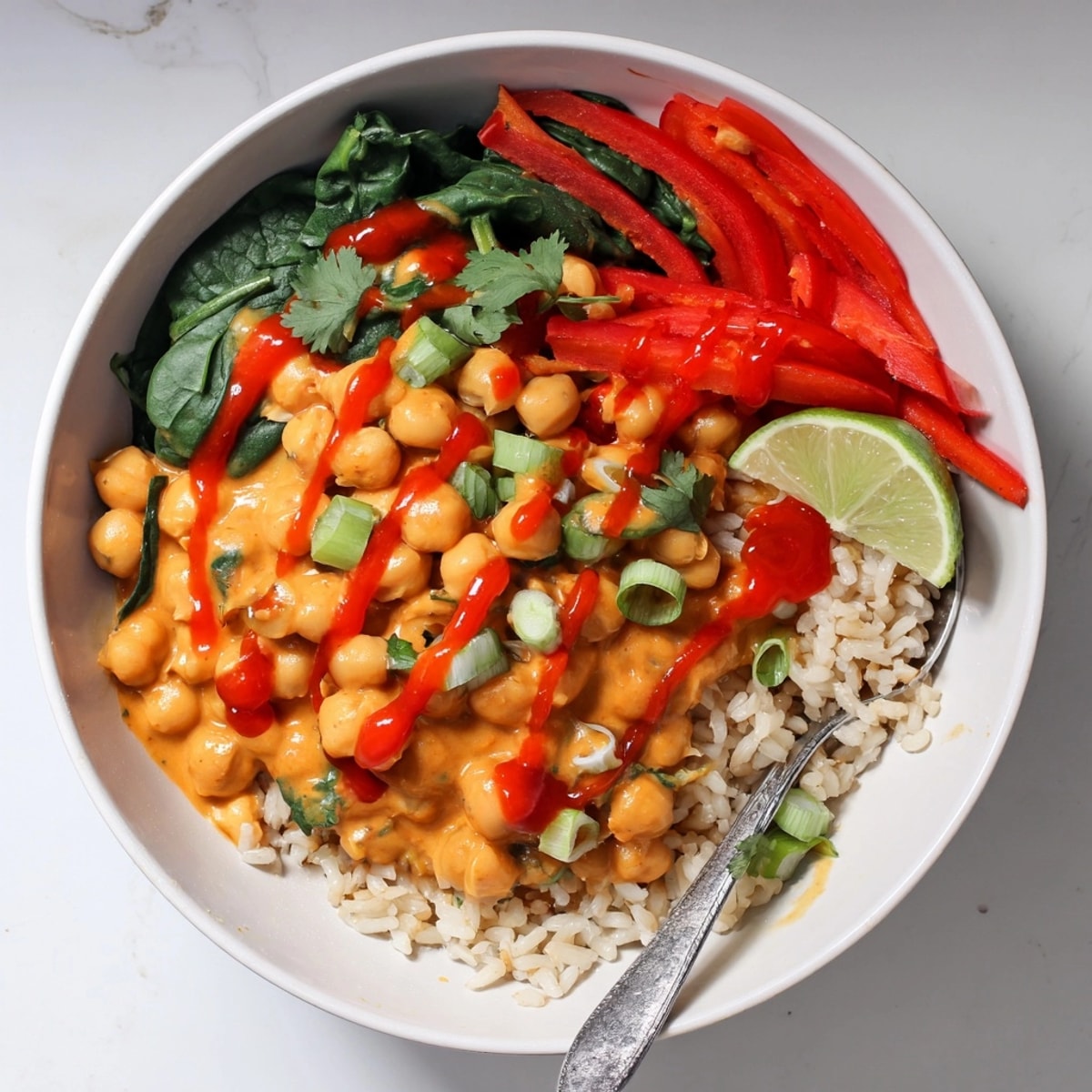 Vegan Thai Red Curry Chickpea Bowls garnished with fresh cilantro and lime wedges, served hot.