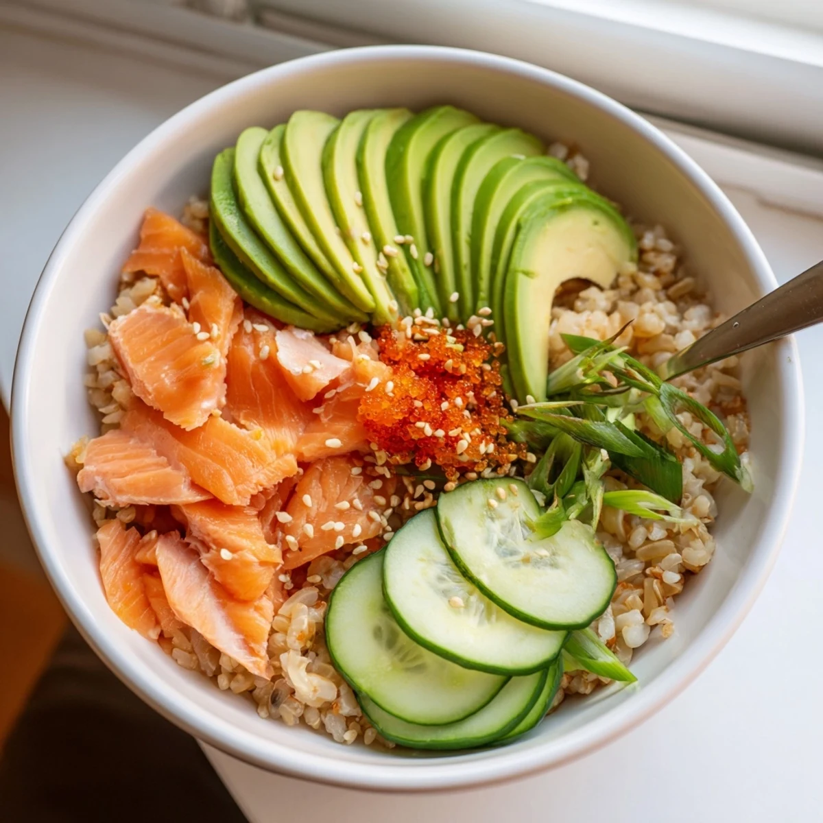 Leftover Salmon & Rice Bowl topped with fresh avocado, cucumbers, and ginger.  