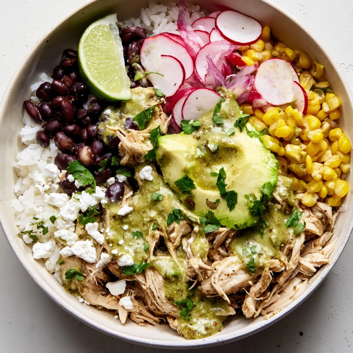 Satisfying Green Enchiladas Rice Bowl garnished with cilantro, radishes, and lime.