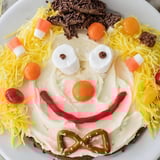 Vibrant Scarecrow Candy Platter with a smiling face, filled with colorful autumn candies for sharing.