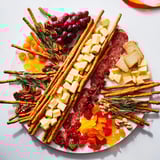 This enticing Flickering Fire Log Snack Board showcases a visually appealing spread with sweet and savory elements.