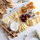 A close-up of a delightful Honeycomb, Honey & Cheese Board, showcasing various cheeses and fruits.