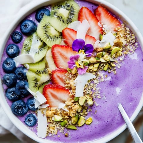 Vibrant smoothie bowls with purple yam and fresh fruit toppings for a healthy breakfast.  