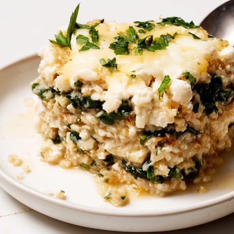 Creamy Alfredo Cauliflower Rice Casserole baking in a dish, topped with melted mozzarella.