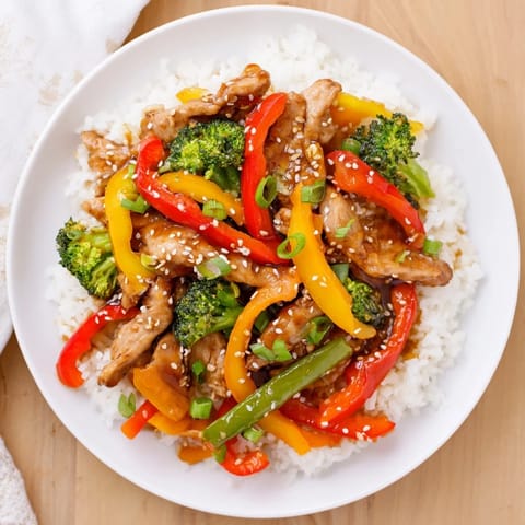 Steaming Chicken Stir-Fry with Vegetables, served over fluffy rice, a complete meal.