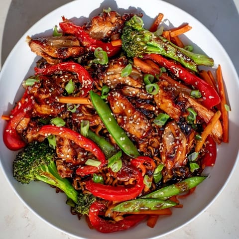 Close-up of Sheet-Pan Crispy Ramen, showing perfectly crisped noodles, tender chicken and glazed veggies.