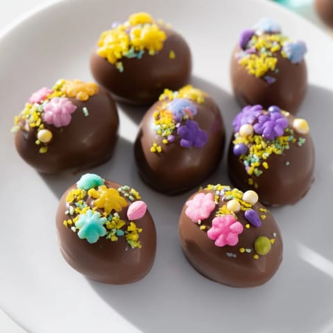 Homemade Easter candy eggs coated in chocolate and topped with colorful sprinkles, perfect for dessert.