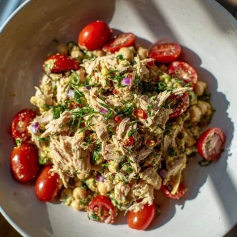 Fresh parsley and red onion top a bowl of delicious, homemade Dense Chickpea and Tuna Salad.