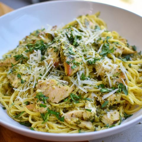 A close-up of pesto egg and chicken pasta, fragrant with fresh basil and Italian flavors.