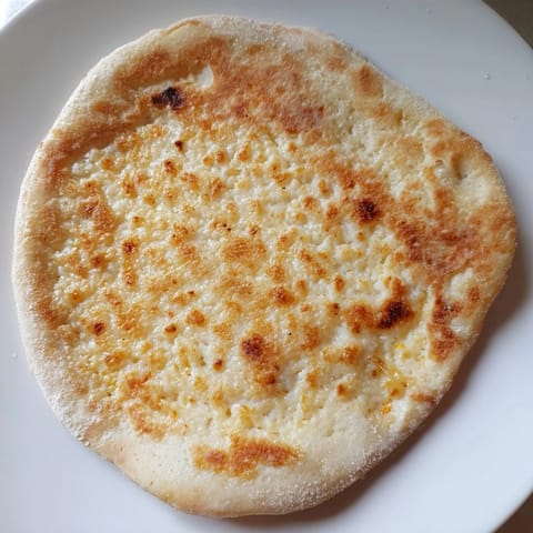 Homemade cottage cheese flatbread, pan-fried to perfection, with textural appeal and savory aroma.