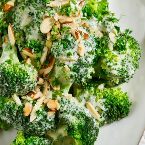 Freshly made Garlic Parmesan Broccoli Salad topped with slivered almonds and parsley, perfect for a light lunch.