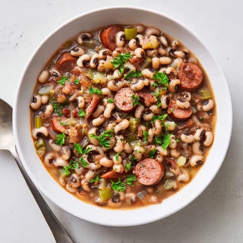 Golden-brown slices of smoked sausage and crispy bacon simmer in a rich pot of Southern-Style Black-Eyed Peas.