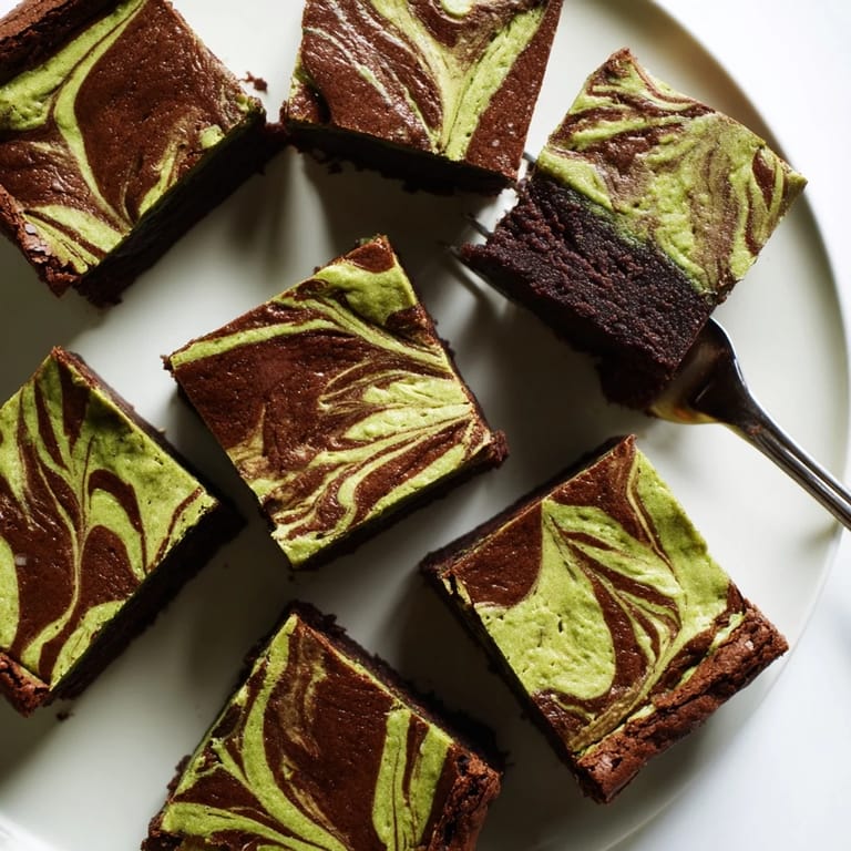 Fudgy chocolate brownies topped with creamy matcha cheesecake, perfect for any dessert table.  