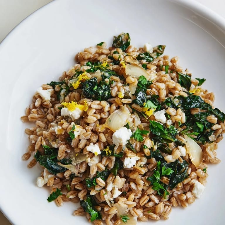 Close-up of a steaming Warm Farro & Greens Pilaf; the farro and almonds offer great textures.