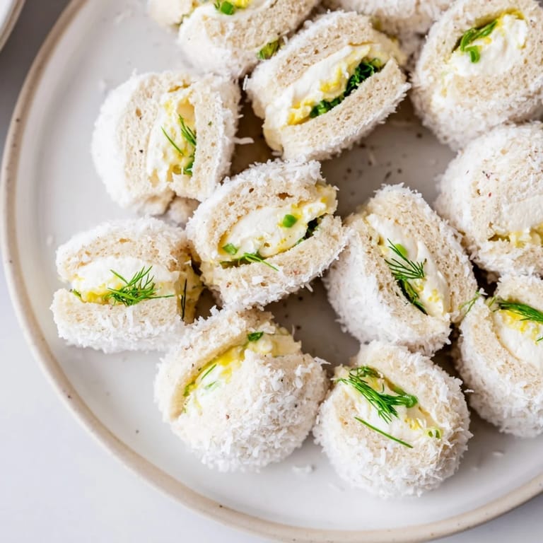 Miniature Snowball Tea Sandwich Bites with visible chives offer a delightful bite of flavor and texture.