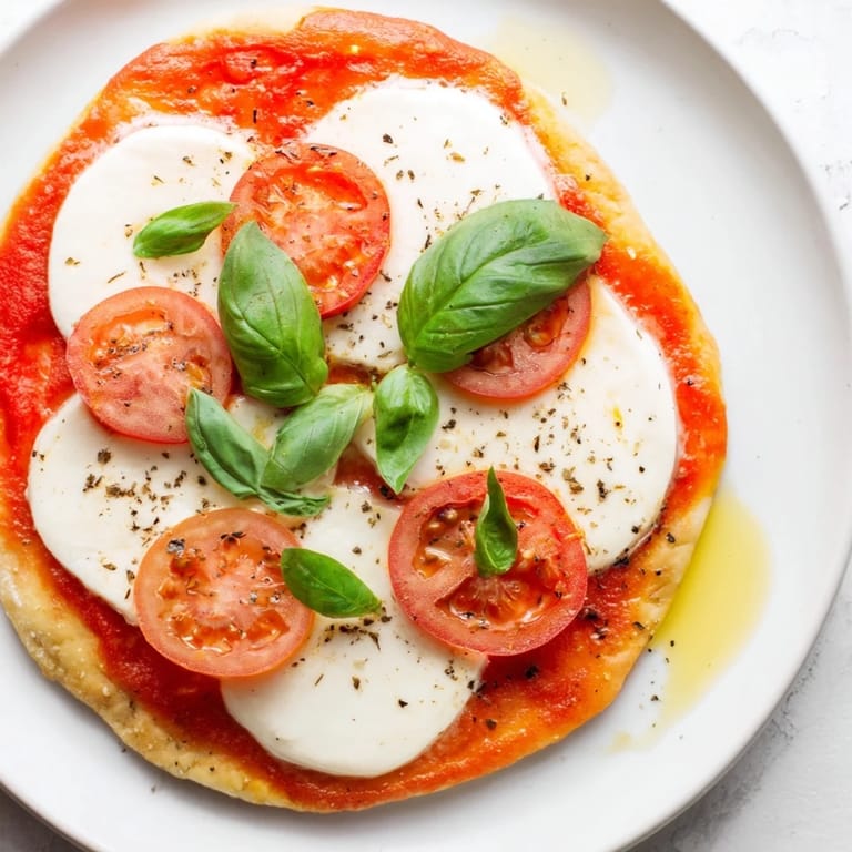 Golden-crusted Quick Margherita Naan Pizza boasting bubbly cheese, fragrant basil, and a delicious tomato sauce.